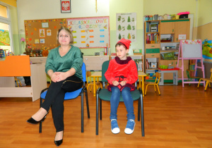 Pani dyrektor Marta Golis wraz z dzieckiem przebranym za krasnala siedzą na krzesełkach