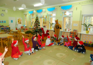 Mikołaj rozmawia z dziećmi z grupy Motylki, które siedzą na dywanie