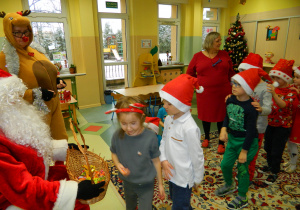 Mikołaj częstuje dzieci cukierkami