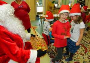 Mikołaj częstuje dzieci cukierkami