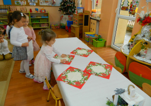 Dziewczynki z grypy Wiewiórek nakrywają stół do obiadu wigilijnego