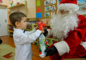 Mikołaj wręcza prezenty dzieciom