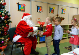 Mikołaj wręcza prezenty dzieciom