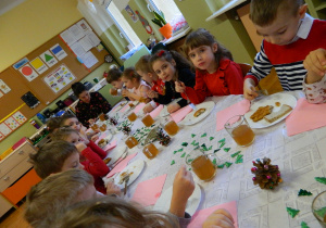 Dzieci z grupy Jeżyków siedzą przy wspólnym stole spożywając obiad wigilijny