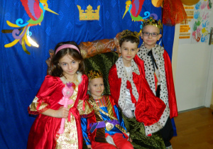 Chłopcy w przebraniach królów oraz Magda jako księżniczka pozują do zdjęcia na tle dekoracji