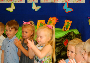 Dzieci klaszczą w ręce w rytm muzyki.