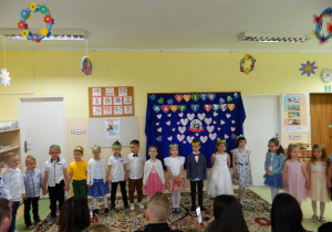 Dzieic z grupy Misiów stoją w półkolu na tle dekoracji.