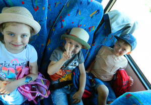 Dzieci siedza w autobusie gotowe na wycieczkę.