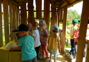 Dzieci bawią się w drewnianym domku.
