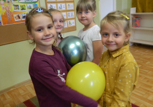 Dziewczynki tańczą z balonem trzymając go brzuchem