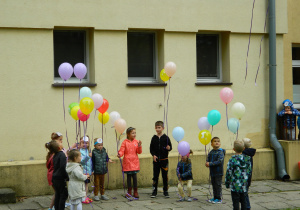 Dzieic z poszczególnych grup trzymają balony w rączkach.