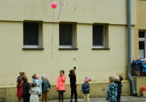 Dzieci wypuszczaja balony z helem w niebo.
