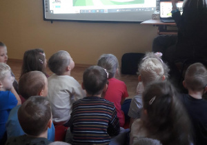 Przedszkolaki oglądaja prezentację na tablicy multimedialnej