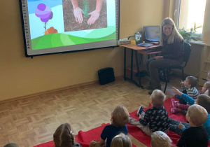 Dzieci oglądaja prezentację multimedialną przygotowana przez Panią leśnik