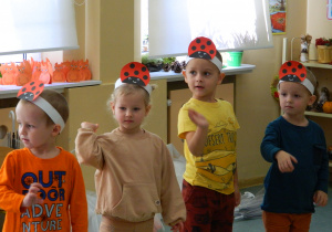 Dzieci z grupy Biedronki tańczą z podniesioną ręką