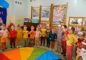 Dzieci trzymają ręce na biodrach stojąc wokół kolorowe chusty