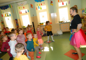 Pani Jesień pokazuje dzieciom taniec, który mają naśladować