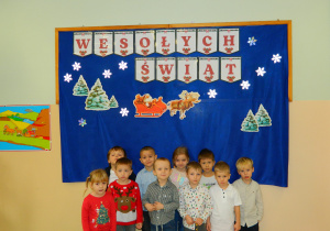 Dzieci z grupy Biedronek stoja przy dekoracji świątecznej