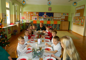 Dzieci wspólnie z nauczycielami jedzą wigilijny obiad