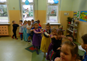 Dzieci trzymają się w pociąg i tańczą