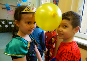 Dzieci trzymają balon pomiedzy swoimi czołami w konkursie