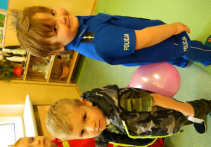 Chłopcy stoją do siebie tyłem i trzymają balon aby nie upadł podczas konkursu