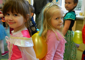 Dziewczynki stoją do siebie tyłem i trzymają balon aby nie upadł podczas konkursu