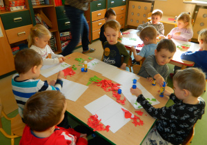 Dzieci z grupy Biedronek wyklejają kolorowym papierem flagę Włoch