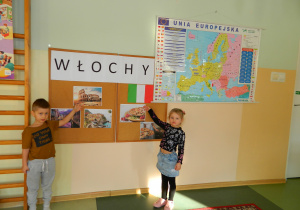 Dzieci z Biedronek wskazują na tablicę z włoskimi ciekawostkami : pizza, budowle, flaga