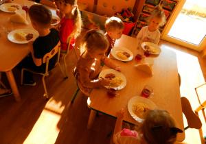 Przedszkolaki w trakcie obiadu jedzą spaghetti