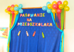 Widok dekoracji na niebieskim tle napis :Pasowanie na przedszkolaka