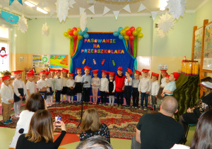 Widok wszystkich dzieci na tle dekoracji śpiewających piosenkę