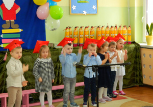 Chłopcy i dziewczynki śpiewają piosenkę i pokazując do niej ruchy