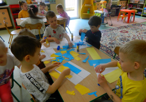 Dzieci z grupy Misie wykonują pracę plastyczną - flagę Ukrainy