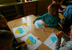 Jeżyki wyklejają skrawkami papieru serca dla Ukrainy