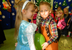 Dziewczynka i chłopczyk w tańcu z balonem