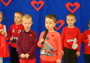 Dwaj chłopcy w czerwonym bluzkach mówią wiersz.