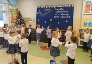 Dziewczynki i chłopcy z grupy Jeżyki tańczą w parach.