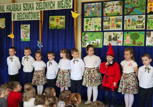 Dzieci stoją na tle dekoracji i recytuja wiersze.