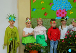 Dzieci w przebranich kwiatów śpiewają piosenkę.