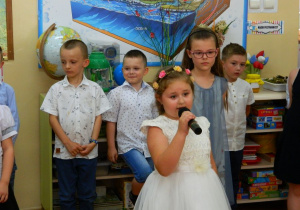 Natalia recytuje wiersz do mikrofonu.