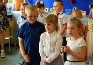 Troje dzieci z grupy Misiów mówi wiersz o rodzicach do mikrofonu.