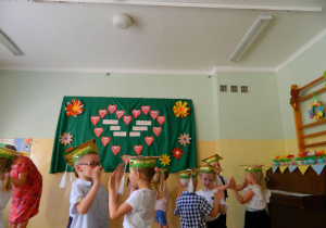 Dzieci z grupy Biedronek klaszczą w dłonie stojąc w parach.