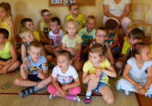 Dzieci z grupy Biedronek siedzą na dywanie.