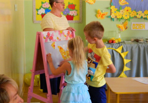 Dwoje dzieci układa puzzle żółtego motyla
