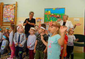 Dzieci wraz z panią Lucynka i panią Dyrektor machają rękoma w rytm muzyki.
