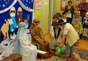 Dzieci przebrane za Maryję i Józefa przyjmują dary od chłopców pasterzy