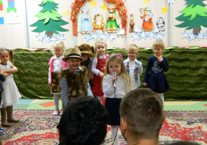 Chłopiec i dziewczynka z grupy Misiów recytują wiersz przez mikrofon.