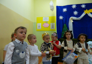 Dzieci z grupy Krasnali na tle dekoracji świątecznej.