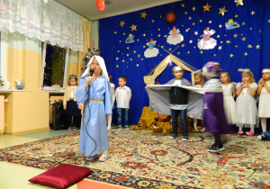 Iga z grupy Biedronek przebrana za Maryję śpiewa kolędę.